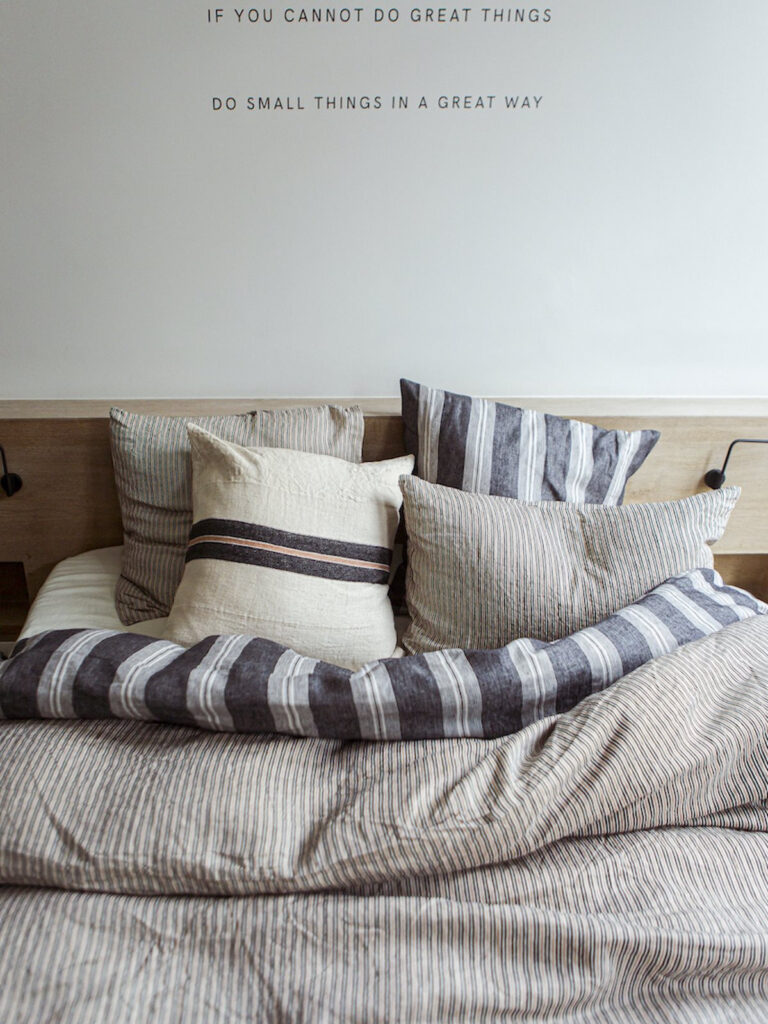 Ein Bett, auf dem ein Haufen Kissen liegt.