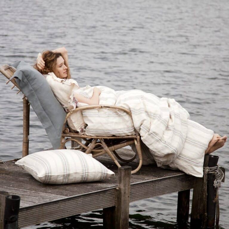 A woman lying on a chair on a jetty.