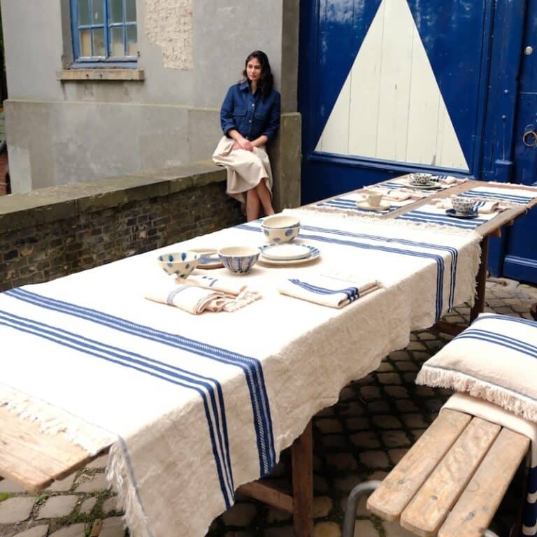 Eine Frau sitzt draußen an einem Tisch.