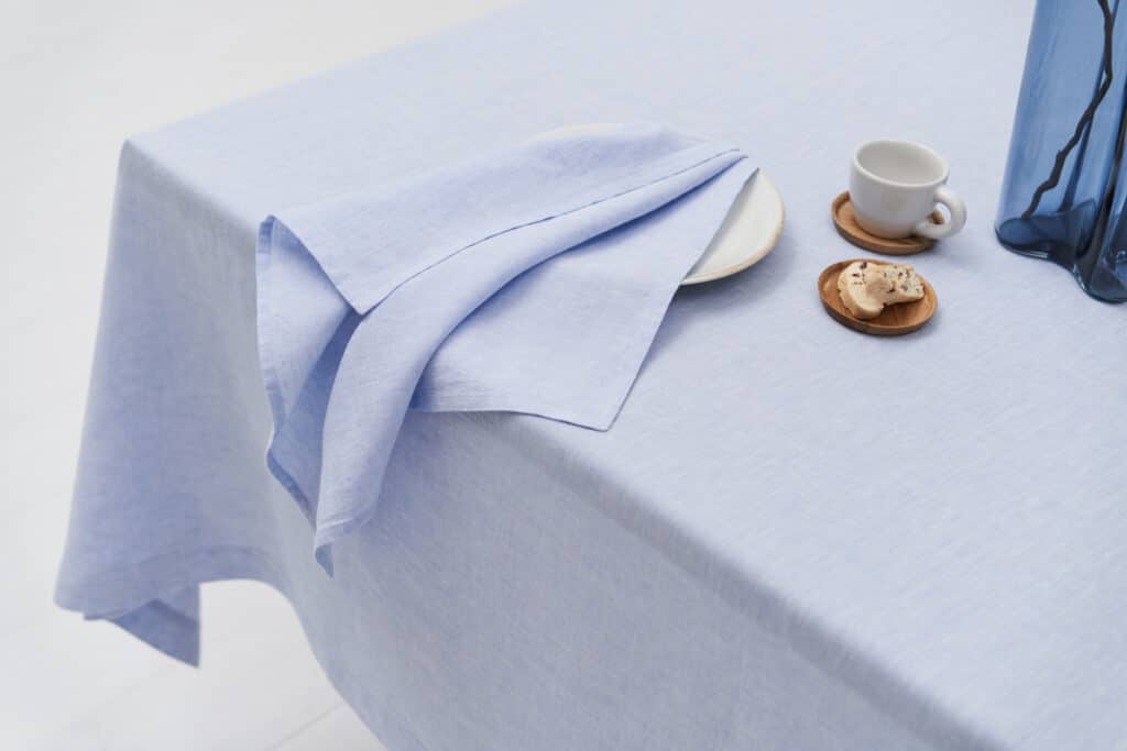 A table with a blue tablecloth and a cup of coffee.