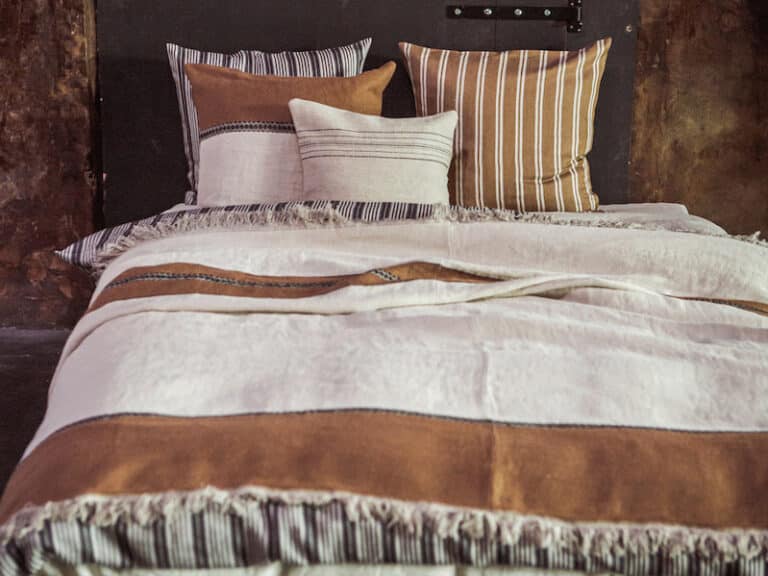Ein Bett, auf dem ein Haufen Kissen liegt.
