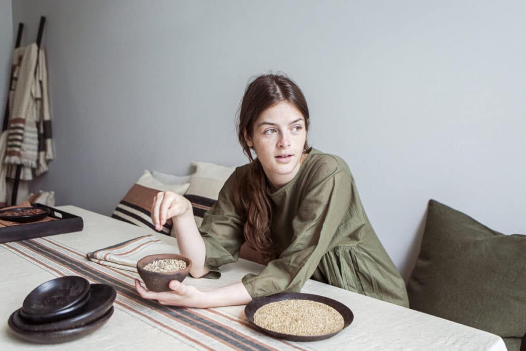 A woman sitting at a table with a plate full of food.