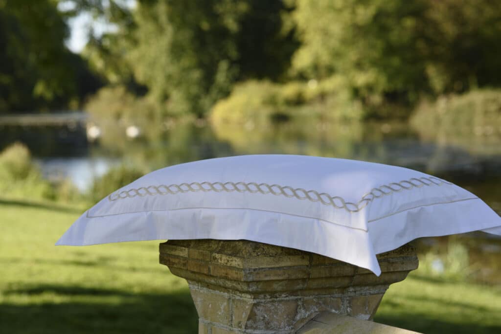 A white pillow sitting on a stone column.