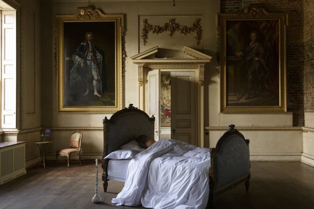 Ein Bett in einem Zimmer mit Gemälden an der Wand.
