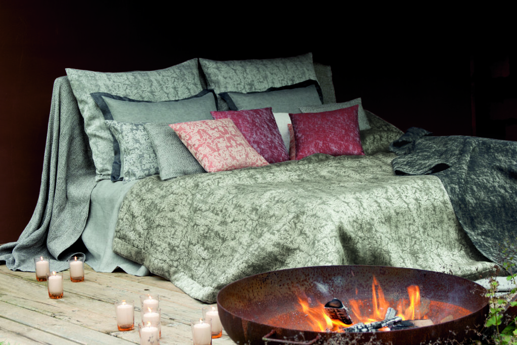 Ein Bett, das neben einer mit Kerzen gefüllten Feuerstelle steht.