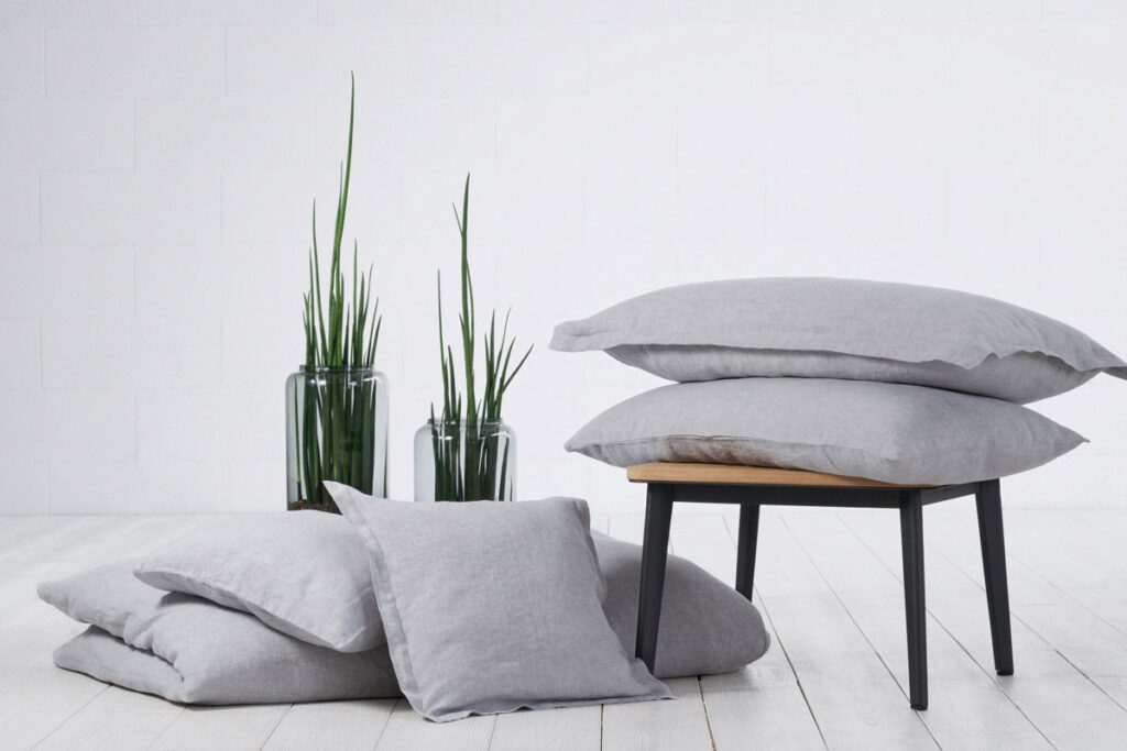 A pile of cushions lying on a wooden table.