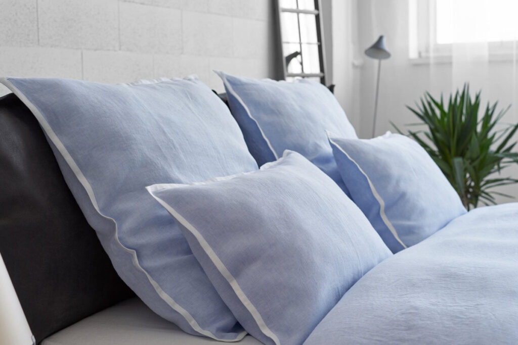A close-up of a bed with blue cushions.