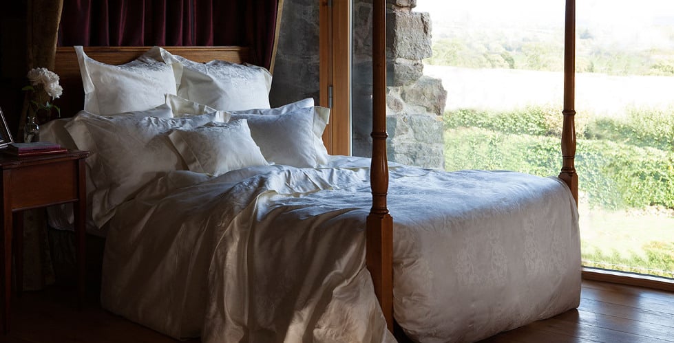 Ein Bett mit einer weißen Bettdecke und Kissen.