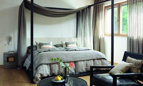 Ein Schlafzimmer mit einem Himmelbett und einem Stuhl.