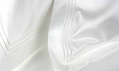 Nahaufnahme der 210TC Percal Bettwäsche von Peter Reed, die sich durch eine glatte, seidige Textur und ein subtiles Streifendesign auszeichnet, das ihre Weichheit und eleganten Falten hervorhebt.