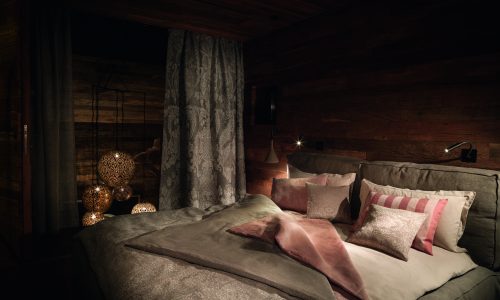 Ein Schlafzimmer mit einem großen Bett und Holzwänden.