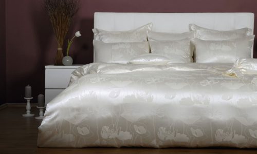 Ein Bett mit einer weißen Bettdecke und Kissen.