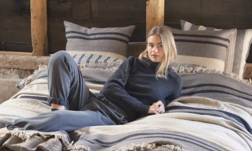 Eine Frau, die auf einem Bett mit einem hölzernen Kopfteil liegt.