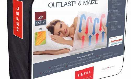 Die Outlast and Maize Ganzjahresdecke von HEFEL kommt in einer überwiegend weißen Verpackung mit roten und blauen Akzenten, die eine Frau auf einem Kissen, Pfeile zur Temperaturkontrolle, Maisbilder und das Outlast-Logo zeigt.