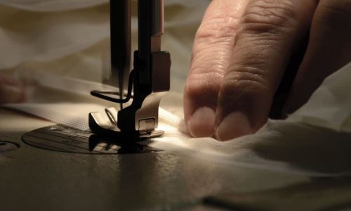 Eine Person, die eine Nähmaschine benutzt, um etwas zu nähen.