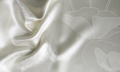 Ein weißes Laken mit einem Blumenmuster darauf.