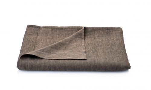 Eine gefaltete braune Stoffserviette mit hochgezogener Ecke ist auf weißem Hintergrund abgebildet und zeigt Erdtöne, die von den Dschungel Leinen Bettlaken von Geniksa inspiriert sind.