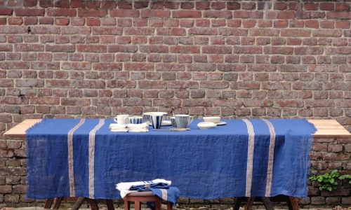 Ein Tisch mit zwei Stühlen und einem blauen Tischtuch.