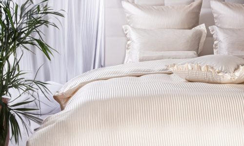 Ein Bett mit einer weißen Bettdecke und Kissen.