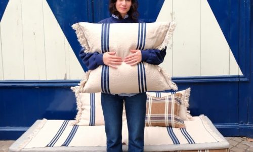 Eine Frau, die auf einer Couch aus Kissen sitzt.