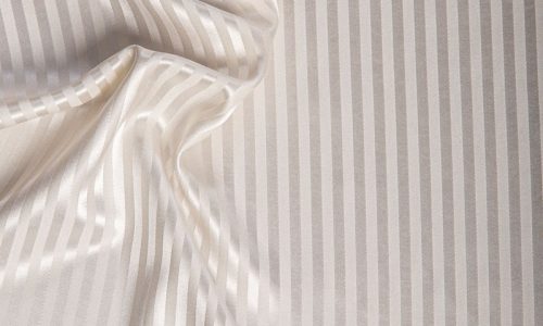 Eine Nahaufnahme eines weiß und grau gestreiften Stoffes.