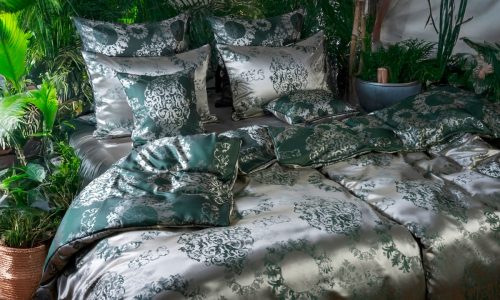 Ein Bett mit einer grün-weißen Bettdecke.