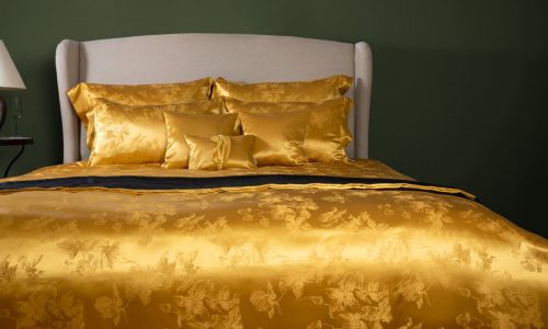 Ein Bett mit einer goldenen Bettdecke und Kissen.