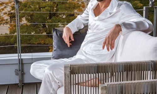 Ein Mann, der auf einer Holzbank sitzt.